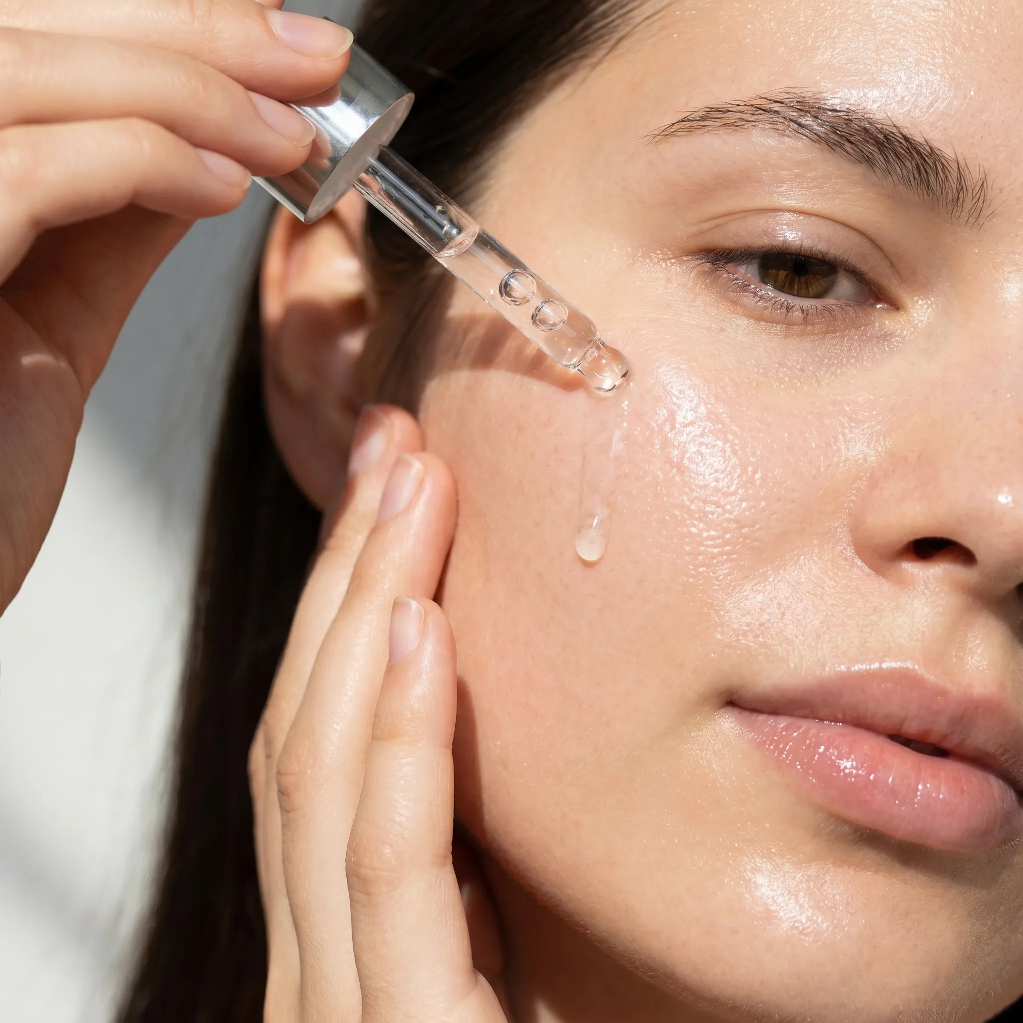 Hand brengt hyaluronzuur serum aan op de huid